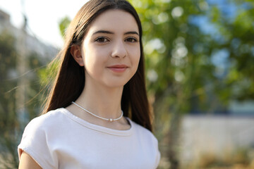 Fototapeta premium Portrait of beautiful teenage girl on city street. Space for text