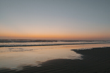 sunset on the beach with sand and reflections