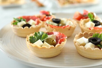 Many tasty canapes on white table, closeup