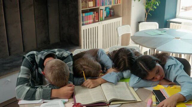 Caucasian four friends pupils tired exhausted fatigued students teens and teenagers boy guy male girls female at school library class sleeping napping on table books sleep together studying education
