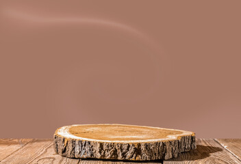 Slice wooden podium round saw cut of a tree on a mocha mousse color background. Still life for the presentation of products. Copy space