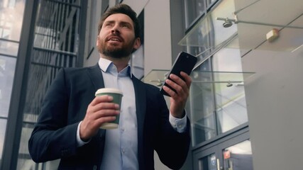 Happy successful smiling middle aged adult Caucasian man male guy business employer businessman entrepreneur walking going in city office building holding coffee cup mobile phone chatting smartphone