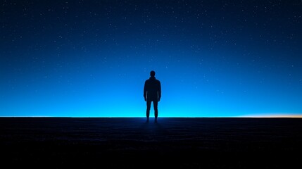 A man standing in the middle of a desert at night