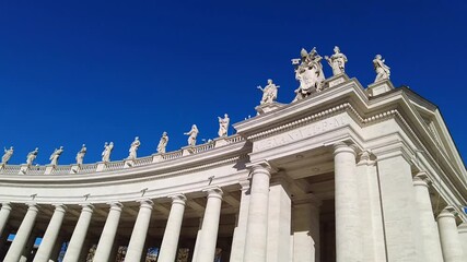 St. Peter's Square in Rome, with its iconic colonnade bathed in sunlight and a long line of tourists weaving toward the majestic basilica. Architecture and flow of modern-day visitors.
