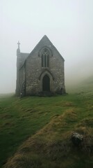 Obraz premium Stone Chapel in the Mist: An enigmatic stone chapel stands alone on a grassy hill, shrouded in an ethereal mist, creating a sense of mystery and isolation.