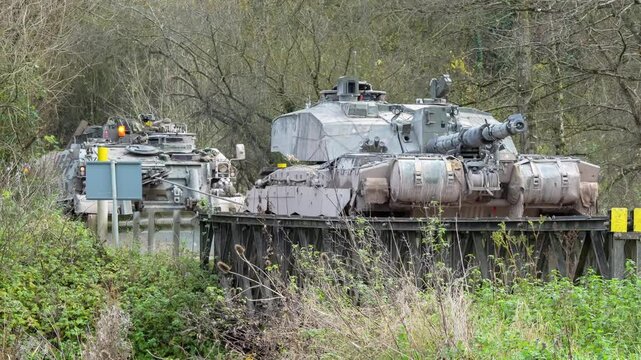 British Army Challenger 2 ii Tank Armored Repair and Recovery Vehicle (CRARRV) winching a Challenger ii 2 FV4034 main battle tank across a road bridge