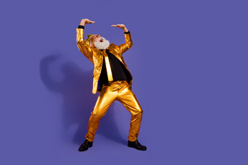Full body portrait of funny eccentric man hold empty space ad golden shiny suit isolated on purple color background