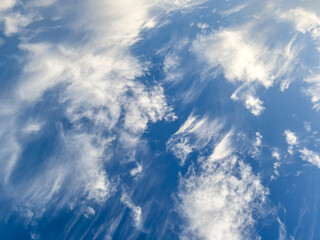Beautiful wispy clouds float effortlessly in a bright blue sky during a sunny afternoon