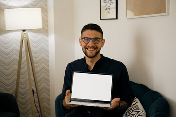 White mock up image blank screen laptop with copy space background for advertising text. Young happy male freelancer holding laptop sitting at home. Marketing and creative design concept.