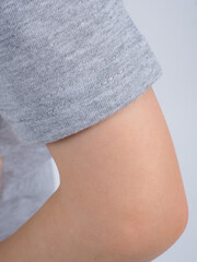 Gray t-shirt on a person. Simple gray t-shirt design. Close-up of gray t-shirt fabric. Minimalist gray t-shirt style.
