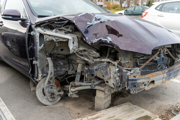 A passenger car is parked in the parking lot with damage to the right front part as a result of an accident.