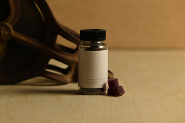 Plain empty blank sleep gummy bottle jar on rustic wood background with vintage pulley