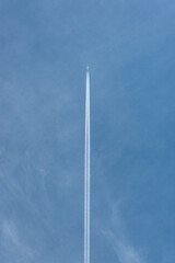 Airbus flying overhead with long contrails. Long smoke trails up above the blue sky