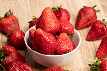 una mesa llena de frutillas con un plato blanco con frutillas