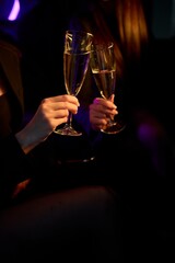 An Elegant Hand Holding a Glass of Exquisite White Wine While in a Luxurious Car Setting