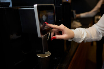 Professional using a touchscreen coffee machine for a convenient coffee break at work