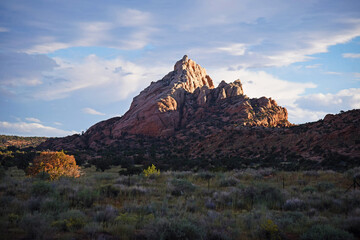 A single red rocky mountain in a field with a fence, taken at sunset, with epic clouds. Taken in USA.