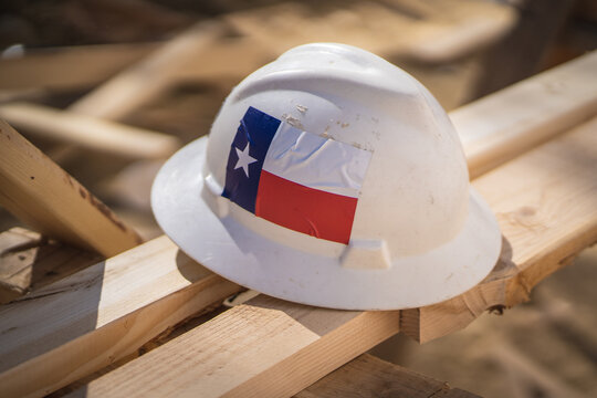 Construction Hat With Texas Flag Sticker on Planks of Wood at Construction 