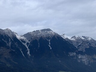 Majestic Mountain Range Covered in Early Snow with Misty Clouds in Moody Skies. Tirol, Austria.