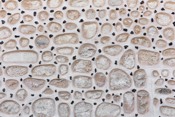 Stone facade of the Alcazar of Segovia, Spain, round stones built in the wall facade with small...