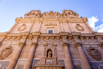 La Clerecia church baroque three sections building facade with the niche with the image of San Ignacio de Loyola, Salamanca, Spain, low angle, symmetrical view.