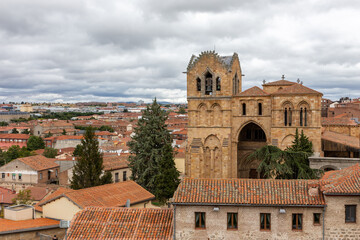 Avila (Spain) cityscape with Basilica of San Vicente romanesque architecture church and tiled rooftops of old medieval buildings, view from Wall of Avila.