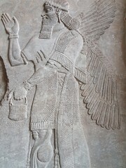 An archeological find of an ancient wall relief inside an Assyrian temple ruin depicts a winged and...