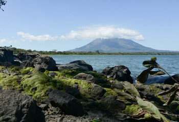 Landscape of Lake Nicaragua or Cocibolca in Ometepe Island in Nicaragua, Central America with Concepcion volcano and rocks with green moho