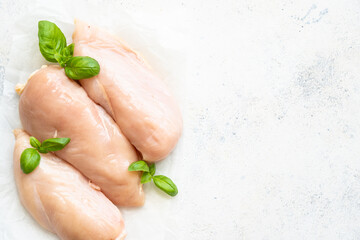 Raw chicken meat, chicken fillet with spices at white background. Top view with space for text.