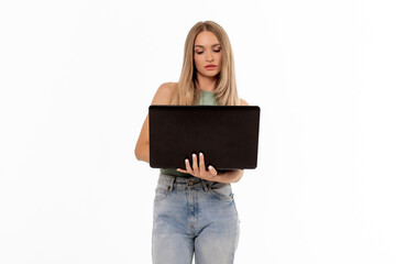 A young woman stands confidently holding a laptop while dressed casually, illuminated against a plain white background