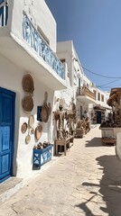 Obraz premium Serene religious buildings, white walls, and blue doors line the streets of Greece Island.