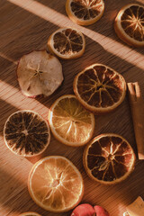 Dried slices of orange and blood orange on natural wooden background, in rustic style top view, pink orange color 