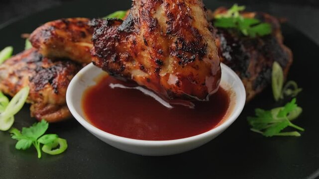 Dipping chicken wings in a bbq sauce