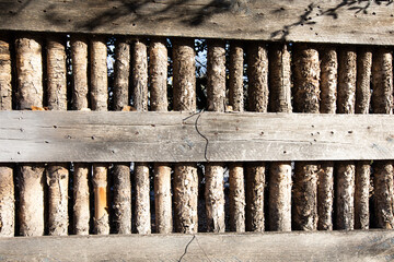 Wooden fence with tree trunk posts on a bright sunny day