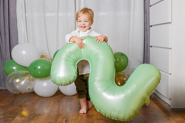 Toddler Celebrating Second Birthday with Green Number Balloon