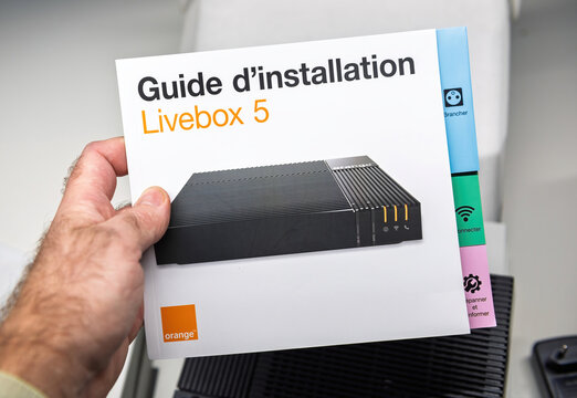 Paris, France - Nov 19, 2021: Close-up of the Orange Livebox 5 installation guide, featuring a clean and user-friendly design for setting up the internet router, highlighting its modern functionality
