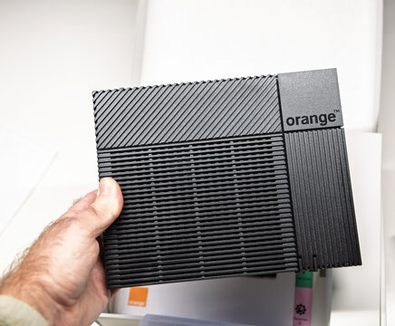 Paris, France - Nov 19, 2021: Close-up of the sleek and compact design of the Orange Livebox 5 router, showcasing its textured black finish and minimalist branding for modern homes