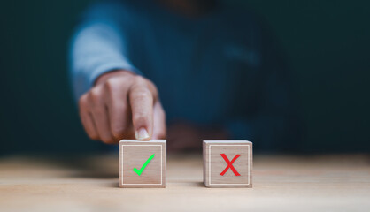 Satisfaction concept. Right or wrong. Businessman touching to wood block of check mark. Approving, voting or right decision. Answer or poll select. Business options for situations.