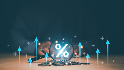 Finance and business growth concept. Coins moneys stacked and magnifying glass with percentage symbol inside and arrow up outside. Financial increase interest rate or mortgage investment dividend.