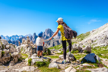 Mother and son hiking in the dolomites admiring tre cime di lavaredo
