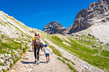 Fototapeta premium Tourists hiking on tre cime di lavaredo trail in dolomites, italy