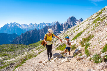 Mother and son hiking on scenic trail in the dolomites, italy © unai
