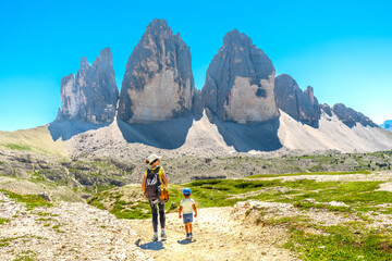 Tourists hiking on trail near tre cime di lavaredo, dolomites, italy, in summer