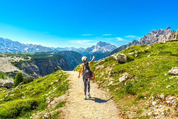 Tourist hiking on tre cime di lavaredo trail in summer dolomites, italy