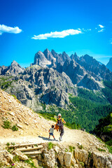 Fototapeta premium Tourists hiking on the scenic tre cime di lavaredo trail in the italian dolomites