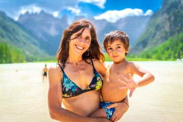 Mother and son enjoying summer swim in the dolomites at lago di landro