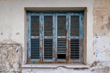 Old shutters with peeling blue paint in the old town on the island of Cyprus in Greece, Paphos, 17.11.2024