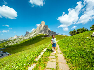 Child running on path at giau pass in dolomites, italy