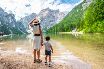 Tourists admiring scenic lake braies in the italian dolomites