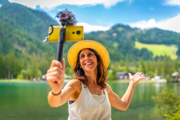 Tourist vlogging at breathtaking lake dobbiaco in the italian dolomites during summer vacation